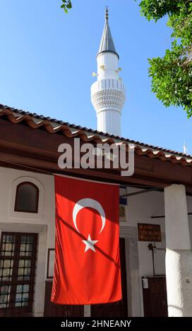 Close-up, red Turkish flag next to the mosque in Bodrum, Turkey. Stock Photo