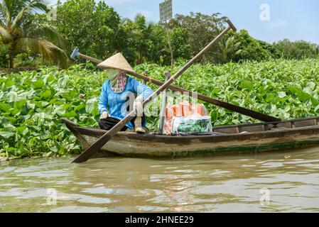 Vietnamese woman with a traditional wooden rowing boat (sampan) on the Mekong River, Mekong Delta, Vinh Long Province, southern Vietnam Stock Photo