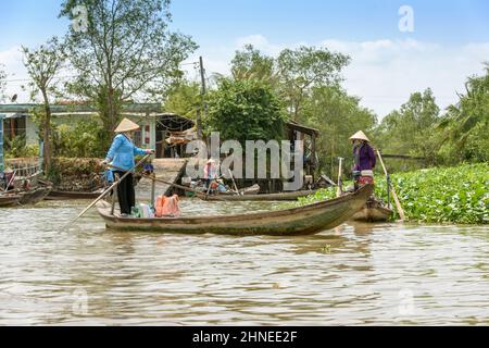 Vietnamese women with traditional wooden rowing boats (sampans) on the Mekong River, Mekong Delta, Vinh Long Province, southern Vietnam Stock Photo