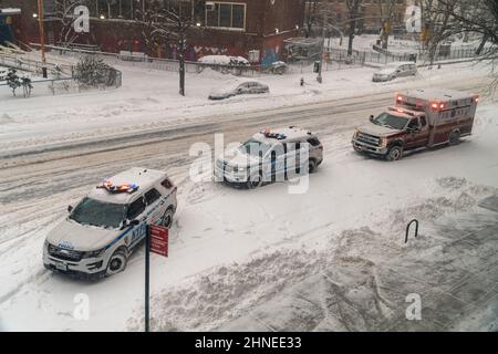 NYPD vehicles and an ambulance on Ninth Avenue the Chelsea neighborhood of New York on Saturday January 29, 2022 during a Nor’Easter which threatens to drop up to 8 inches in the city according to some weather reports. The storm is expected to blanket the Northeast with some unlucky areas expected to receive over a foot of snow. Yikes!.  (© Richard B. Levine. Stock Photo