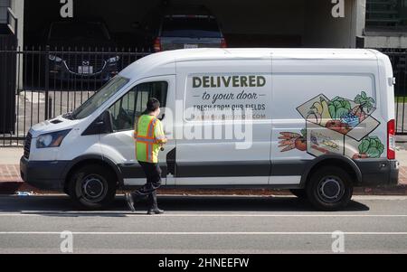 Los Angeles, CA / USA - March 29, 2020: A Farm Fresh To You organic produce delivery van is shown, with the driver wearing a mask during the COVID-19 Stock Photo