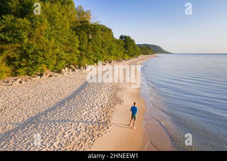 Lonely man on desolate sandy beach of Knäbäckshusen / Knaebaeckshusen along the Baltic Sea, Österlen in Ravlunda, Simrishamn, Skane / Scania, Sweden Stock Photo