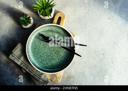 Minimalistic table setting on a chopping board with two houseplants Stock Photo