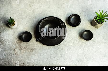 Overhead view of a minimalistic Asian table setting with two houseplants Stock Photo