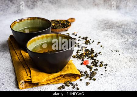 Two cups of Green sencha tea with dried mango Stock Photo