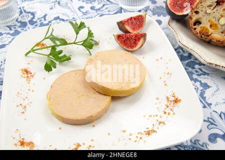 foie gras accompanied by dried fruit bread with fresh figs on a plate Stock Photo