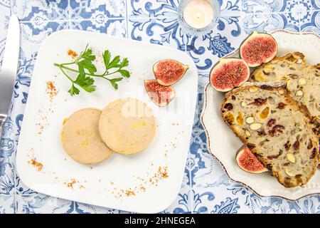 foie gras accompanied by dried fruit bread with fresh figs on a plate Stock Photo