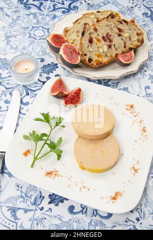 foie gras accompanied by dried fruit bread with fresh figs on a plate Stock Photo