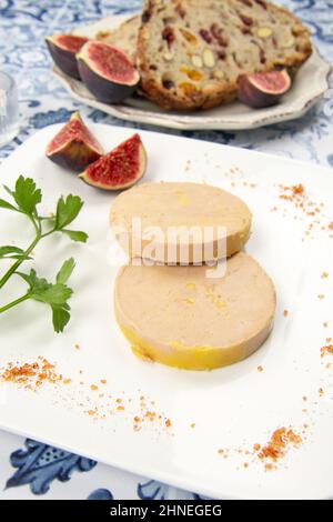 foie gras accompanied by dried fruit bread with fresh figs on a plate Stock Photo