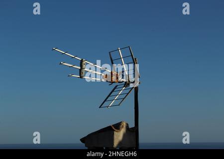 Rooftop TV antenna against a clear blue sky Stock Photo