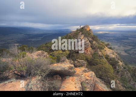 Rocky quartzite outcrop and storm clouds over rural landscape,  South Australia, Australia Stock Photo