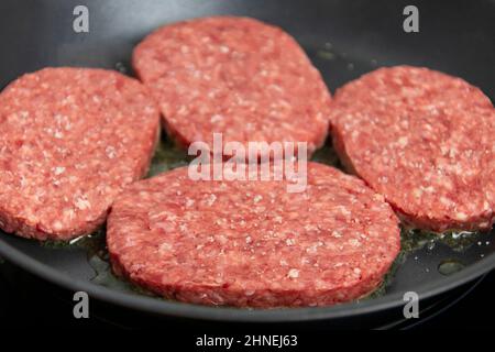 raw ground beef cooking in a skillet Stock Photo