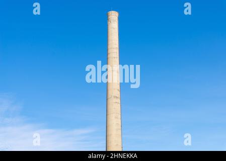 Old smoke stack with blue skies in the background. Stock Photo