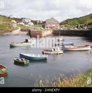 1960s, historical view from this era of the small harbour at Porthgain, Wales, UK. Located on the Pembrokeshire coast, in the early 1900s, the harbour was used to export slate from the nearby quarries and then on the quay, brickmaking was established there, using the waste from the slate mining. Stock Photo