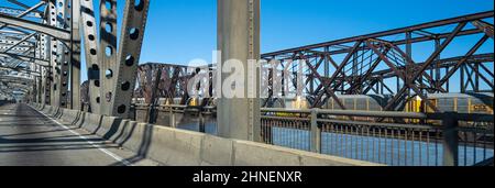 View from the Memphis-Arkansas Bridge over the Mississippi River of a train crossing the Frisco Bridge with the Harahan Bridge in the background. Stock Photo