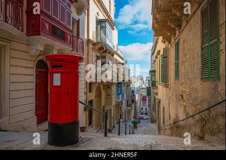 Red vintage old fashioned mail box on narrow street with stairs in Valletta, Malta. Stock Photo