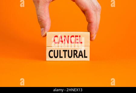 Cancel cultural symbol. Concept words Cancel cultural on wooden blocks on a beautiful orange table orange background. Businessman hand. Business and c Stock Photo