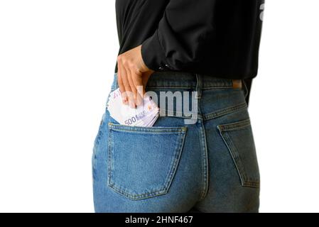 500 euro notes in a jeans back pocket. Isolated image woman putting money in her pocket Stock Photo