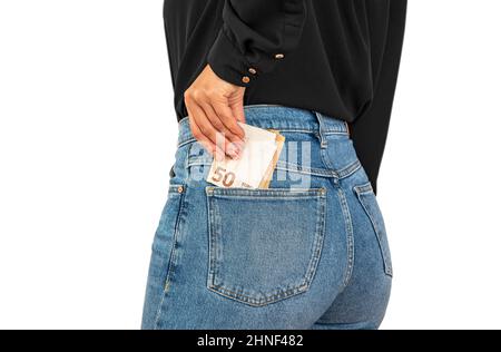 Woman with her hand putting 50 euro bills in her back pocket of jeans, isolated folded 50 euro banknotes in cash Stock Photo