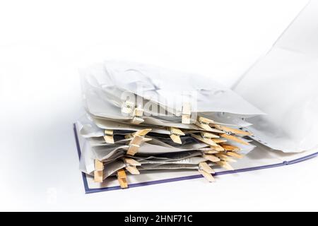Ring binder or document folder with transparent punched pockets full of receipts closed with wooden clothespins, accounting and tax calculation, offic Stock Photo