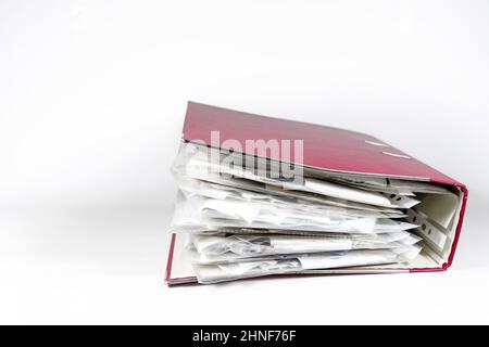 Red ring binder full of transparent punched pockets with receipts, office accounting concept, light gray background, copy space, selected focus, narro Stock Photo