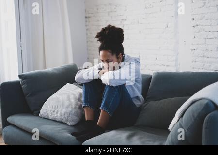 Young devastated depressed African American woman crying feeling sad, hurt suffering depression sadness and emotional pain. Mental health in young Stock Photo