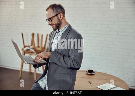 Bearded man using modern laptop in cafe Stock Photo