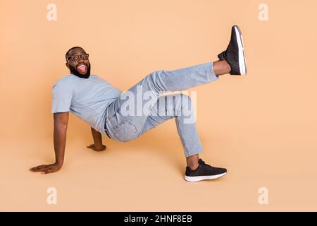 Portrait of attractive cheerful guy dancing break having fun performance isolated over beige pastel color background Stock Photo
