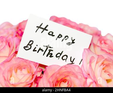 The inscription on the sheet for notes 'Happy birthday' on the background of a bouquet of roses Stock Photo