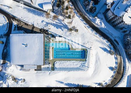 View from the top of a heated outdoor swimming pool in the snow . Sestriere, Italy - February, 2022 Stock Photo