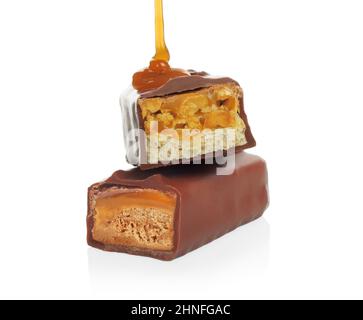 Pouring caramel on broken chocolate bars on white background close-up Stock Photo