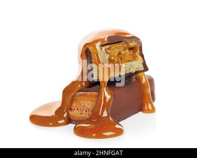 Pouring caramel on broken chocolate bars on white background close-up Stock Photo