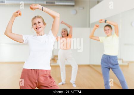 Woman performing aerobic dance during group training Stock Photo