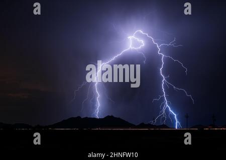 A pair of lightning bolt strikes from a thunderstorm in the night sky near Casa Grande, Arizona Stock Photo