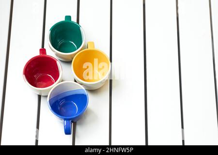Four cups on a white striped table Stock Photo