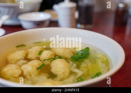 Selective focus at dumpling on wonton hot Chinese soup. Stock Photo