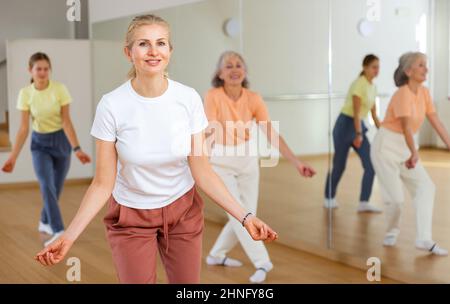 Woman performing jazz style dance during group training Stock Photo