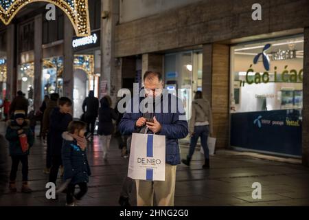 Picture of one man, senior white male caucasian, looking confused at a mobile phone in the middle of a street of belgrade, serbia, at night. Stock Photo