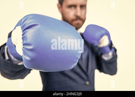 Businessman stand in fighting position wearing blue boxing gloves selective focus, punching Stock Photo