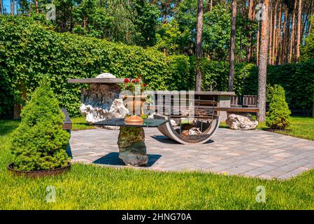 Iron fire pit with bench on stone pavement in garden backyard Stock Photo
