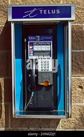 A pay phone on an exterior wall of a shopping mall in British Columbia Canada Stock Photo