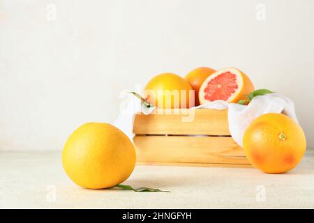 Box with delicious grapefruits on light background Stock Photo