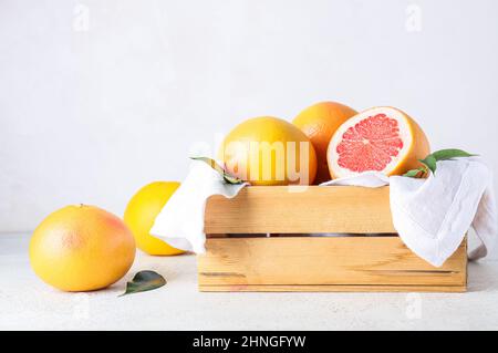 Box with delicious grapefruits on light background Stock Photo