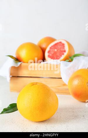 Box with delicious grapefruits on light background Stock Photo