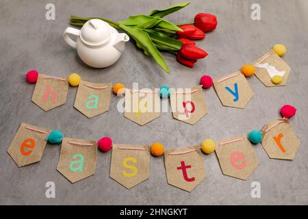 Easter colourful lettering on grey . Easter still life with tulips. Stock Photo