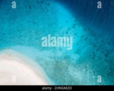 Aerial view of a tropical island with a turquoise lagoon, lush green ...