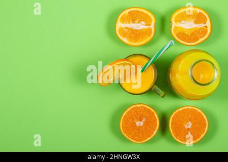 Glass of orange juice on solid green table. View from above Stock Photo