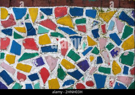 Multicolored mosaic on the exterior wall. Multicolored geometric shapes in a white wall. Abstract background Stock Photo
