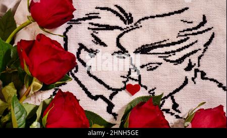 Embroidered picture of a couple in love with black thread with red flowers roses. A wonderful incredible unique gift for a loved one on a special day, holiday, event. Stock Photo