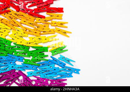 frame from multi colored wooden decorative clothespins, horizontal photo with place for text on white background and copy space Stock Photo